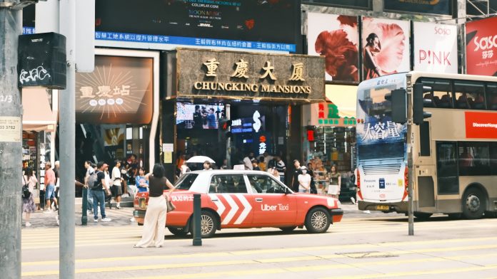 A double decker bus driving down a street next to tall buildings
